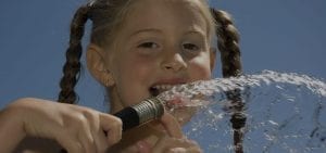 Girl drinking from hose